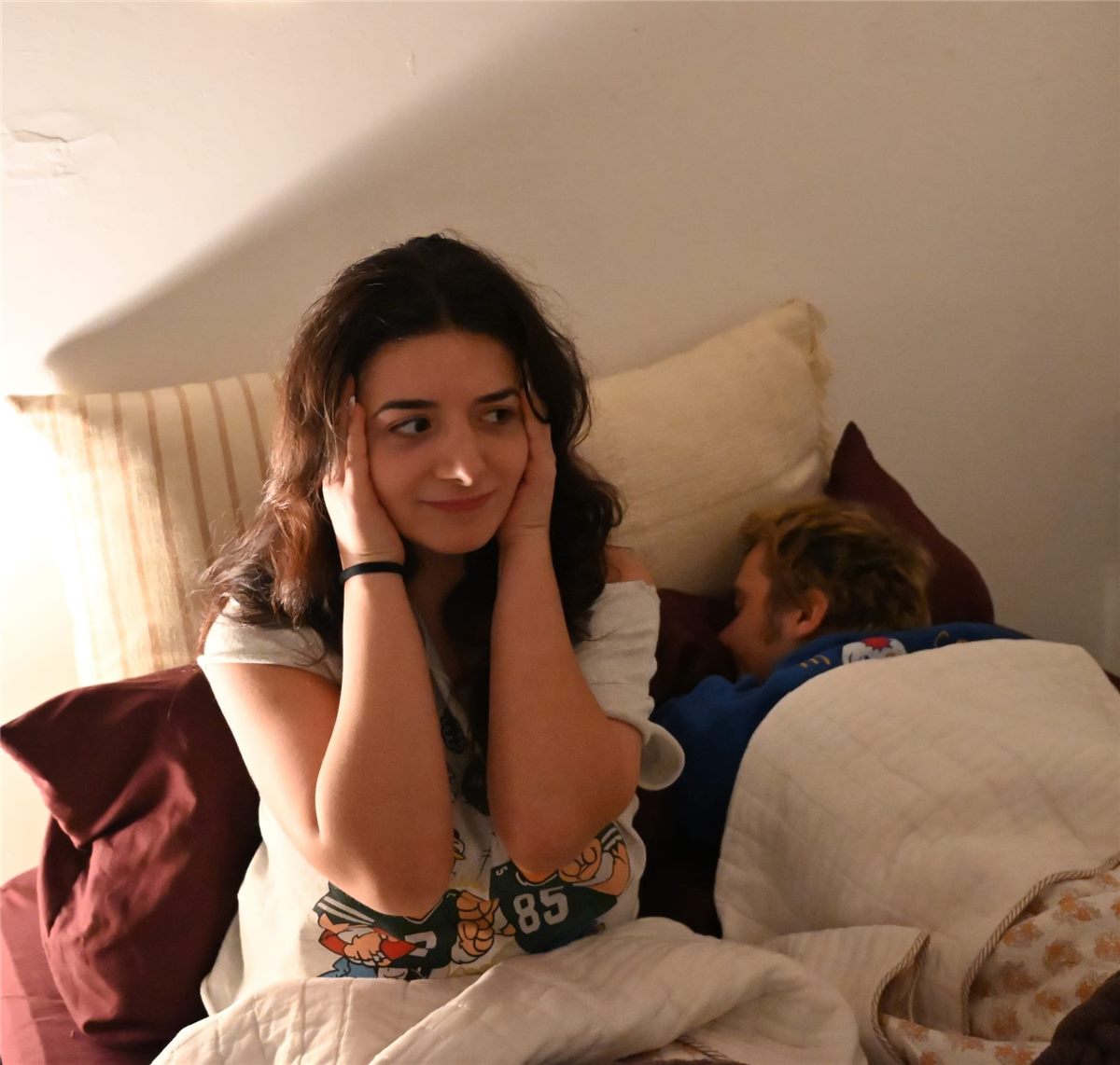 Person covering their ears next to a snoring partner