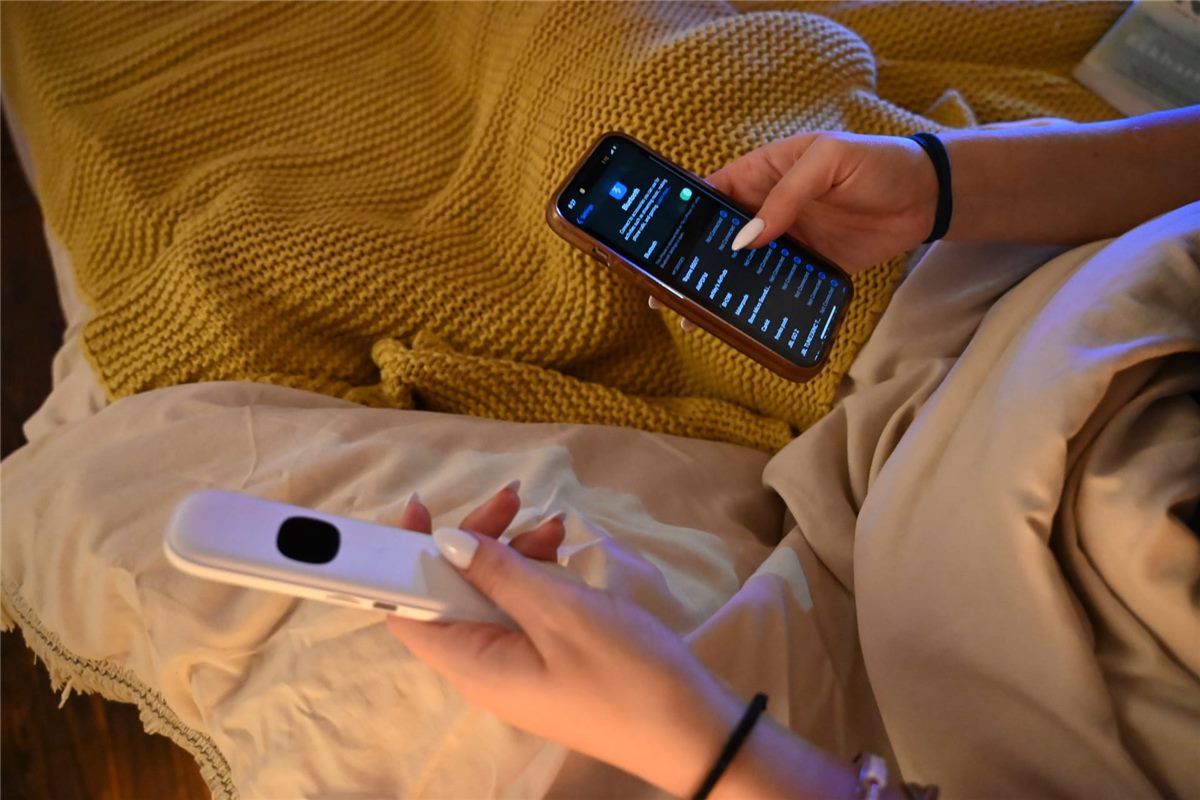 Hands placing a Lullabar pillow speaker under a pillowcase