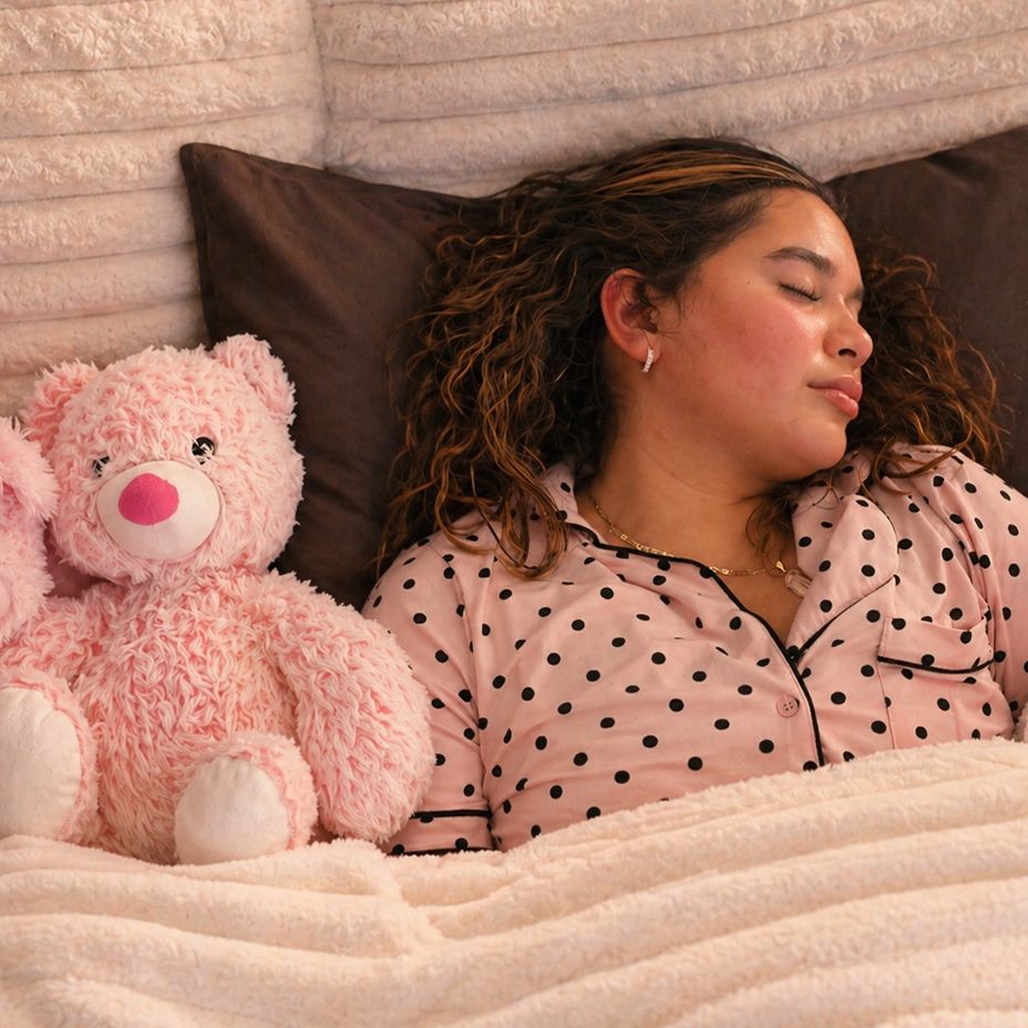 Woman asleep in bed with steady background sound playing