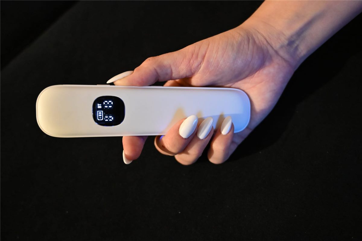 Hand holding the slim Lullabar pillow speaker