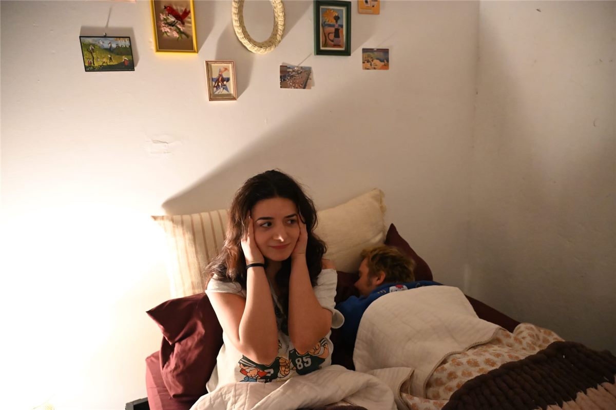Person lying awake next to a snoring partner